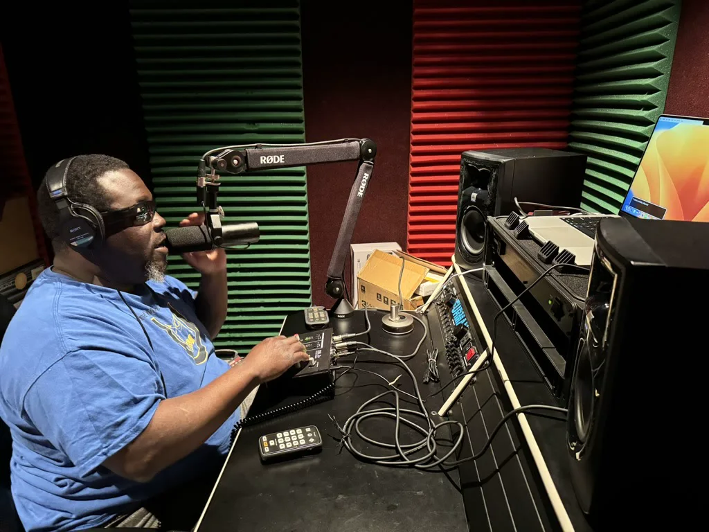 Edward Hood, wearing headphones, works at a Pro Tools training station in a recording studio.